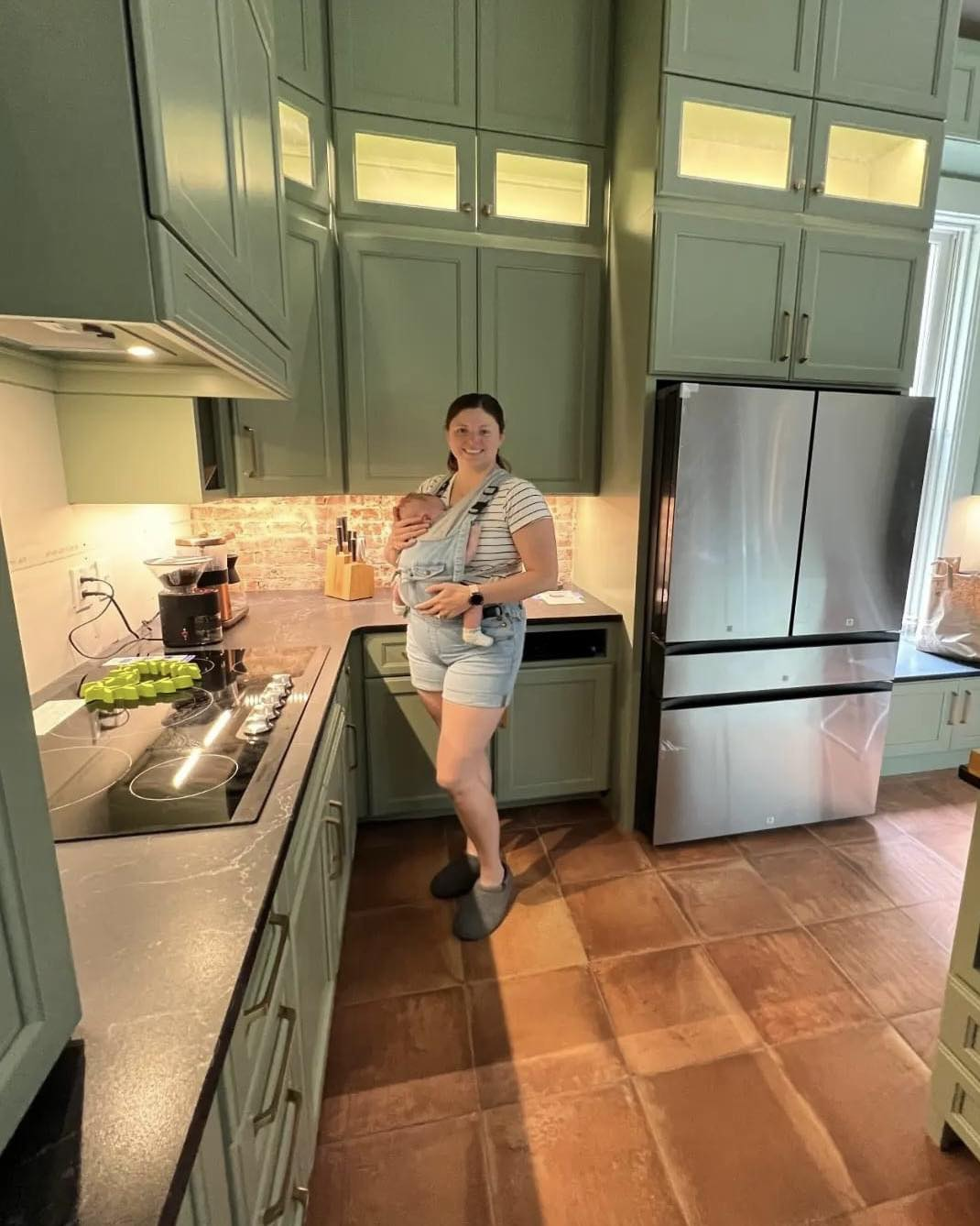 Custom green kitchen cabinetry with tall upper cabinets and dramatic height
