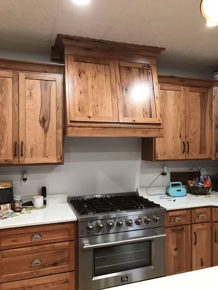 Warm wood custom kitchen cabinetry above a professional range